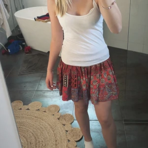 Jättefin sommar kjol - Säljer en färgglad kortkjol med patchworkmönster i rött, rosa, blått och beige. Kjolen har resår i midjan och är luftig med flera olika mönster, vilket gör den väldigt unik. Verkligen superfin och passar till mycket. Säljer pga den knappt används❣️Lappen har på något sätt försvunnit, men den är från en affär i afrika.