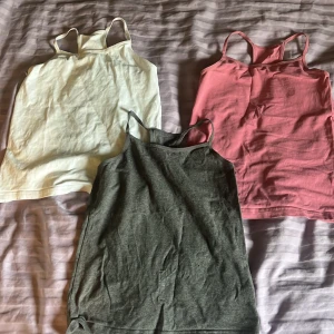 Rosa, vit och grå  linnetopp med smala axelband -  Säljer tre enkla linnen, en vit en grå och en rosa . Känns väl det härliga på storlek ungefär 134 ungefär de är från Next jag gillat de inte använt dem för många gånger de blev för små dock