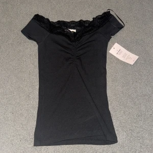 Svart ribbad topp med spetskant - Supersnygg svart ribbad topp från Nelly. Aldrig använd med prislapp kvar. Skriv för mer info å bilder! (öppet pris) Skriv innan du köper