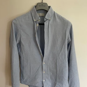 Ljusblå skjorta från Casual Friday - Säljer denna feta casual friday skjortan. Den har ett par snygga detaljer som syns på bilden. Passformen är riktigt snygg på. Har ni funderingar är det bara att skriva🎱