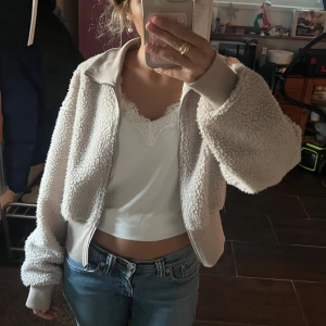 Beige teddyjacka med dragkedja - Supermjuk och fluffig beige teddyjacka med dragkedja framtill. Jackan är tight i midja, samt har en hög krage. Den är från Cubus och är i storlek S men skulle säga att den passar en xs också!