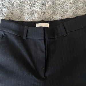 Svarta kostymbyxor från H&M - Klassiska svarta kostymbyxor med diskreta ränder från H&M i storlek 38🖤