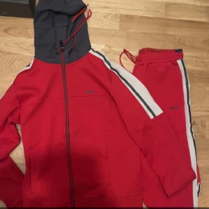 Hugo boss dress - Hugo boss dress i nytt skick använt ett få tal gånger med en snygg röd färg. Det är både storlek M i byxorna och kofta.