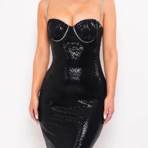 Svart glittrig långklänning Label Nue - Supersnygg svart långklänning från Label Nue med glittriga paljetter över hela klänningen. Den har smala axelband med strassdetaljer, markerad byst och en slits framtill. Klänningen är figurnära och har dragkedja i ryggen. Perfekt för dig som vill sticka ut.