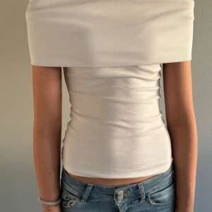 Vit offshoulder topp  - Snygg vit offshoulder topp. Modellen är figurnära och ärmlös, perfekt för dig som gillar en stilren och trendig look. Passar till jeans eller kjol för en fräsch outfit. Nyskick, endast använd 2 gånger. Nypris ca 300 kr – säljs för 150 kr. 🫶🫶