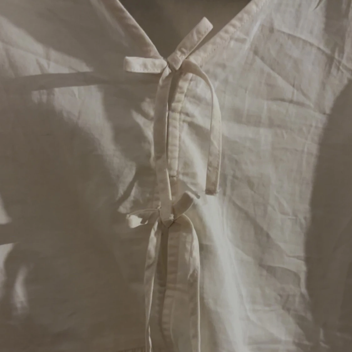 Cremevit blus med rosetter  - 1