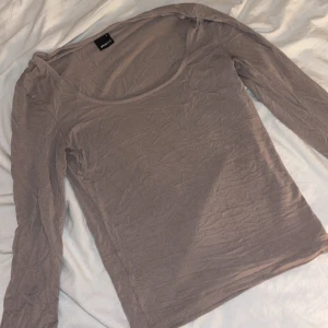 Beige långärmad topp från Gina - En enkel och stilren beige långärmad topp från Gina. Toppen har rund halsringning och är tillverkad i mjuk bomull.