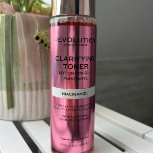 Revolution Clarifying Toner Niacinamide - Clarifying Toner från Revolution med niacinamide och kamomillextrakt för extra återfuktning och klarhet. Kommer i en snygg metallicrosa flaska med silvrigt lock, 200 ml. Vegansk och cruelty free formula som passar perfekt i din hudvårdsrutin.