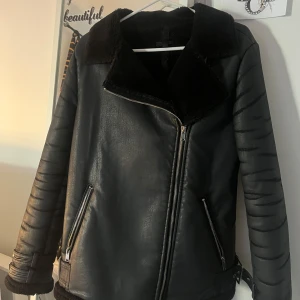 Svart skinnjacka med fuskpäls - Snygg svart skinnjacka med bred krage i fuskpäls. Använd 1 vinter men kommer inte till användning längre sträcken på armarna syns inte när man väl har på sig jackan. Jackan är från missguided skriv för fler bilder💞