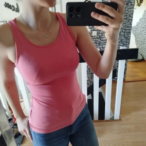 Rosa linnetopp - Säljer en snygg rosa linnetopp med rund halsringning. Toppen har en tight passform och är perfekt för varma dagar. Passar bra till jeans eller kjol för en avslappnad look.