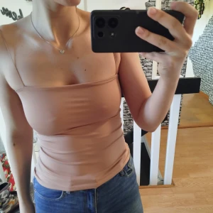 Beige linnetopp - Säljer en stilren beige linnetopp med smala axelband. Perfekt för varma dagar eller som ett basplagg i garderoben. Enkel och snygg design som passar till det mesta.