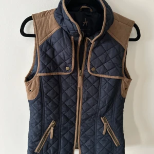 Marinblå väst - Marinblå väst med bruna mockadetaljer. Står ingen eu storlek i västen (se sista bild), men skulle  säga att den upplevs som en stl s.