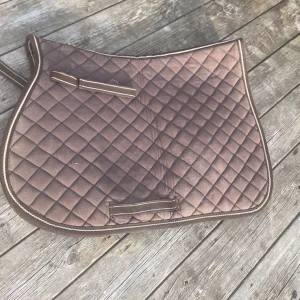 Schabrak  - Säljer detta fina bruna schabrak då jag inte längre rider och vill bli av med. Osäker vad det är exakt för storlek men passade för b ponnyn jag red och hade kunnat passa häst också. har tyvärr ingen möjlighet att tvätta de men försöker få bort så mycket hår som möjligt. Använt då o då men fortfarande i bra skick. Inget speciellt märke