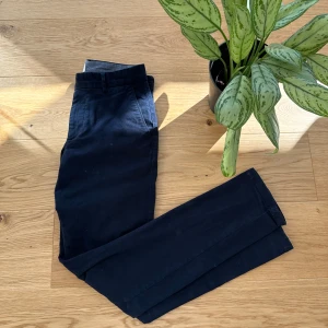 Svarta chinos från John Henric - Snygga svarta chinos från John Henric. De har en klassisk design med knappar och dragkedja. Perfekta för en stilren look.