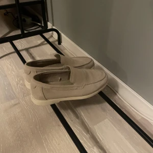 Zara loafers - Säljer dessa stilrena beiga loafers i mocha från zara. Använda vid fåtal tillfälle och är i ett bra skick men finns tecken på användning.