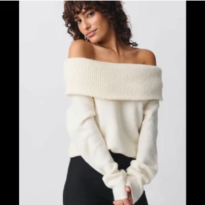 Vit offshoulder tröja - Säljer en stilren vit offshoulder tröja med ribbad kant. Perfekt för en elegant look med långa ärmar och mjukt material. Passar både till jeans och kjol för en chic outfit.