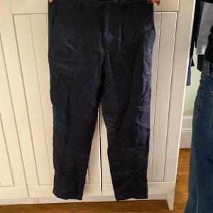 Mörkblå byxor från Zara - Snygga mörkblå linnebyxor från Zara i en klassisk stil. De har en elastisk midja för extra komfort och en rak passform. Perfekta för en stilren look.