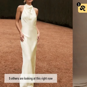 Gul  långklänning i satin - Elegant vit långklänning i satin med öppen rygg och halterneck-design. Perfekt för speciella tillfällen. Från Meshki