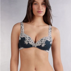 Mörk blå spets super push up bh intimissimi  -  75D. Elegant mörk blå bh från intimissimi med vacker spetsdetaljering i kontrasterande färg. Justerbara axelband och hakknäppning bak för perfekt passform. Perfekt för att känna sig extra fin. Ser perfekt ut med toppar som är lite genomskinliga.(Den ser svart ut på bilden men är navy blue) (Använder inte eftersom den är för stor för mig💘)