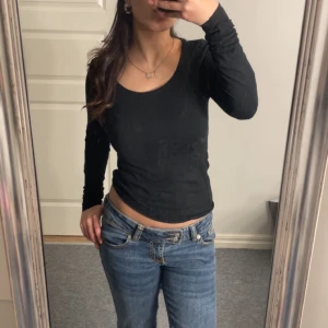 Svart långärmad topp - Säljer en stilren svart långärmad topp med rund halsringning. Perfekt för en enkel och snygg look. Passar bra till jeans eller kjol.