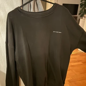 Svart tröja från The Classy Issue - Säljer en svart tröja från The Classy Issue med ett unikt tryck på baksidan. Tröjan har en rund halsringning och långa ärmar. Perfekt för en avslappnad stil.