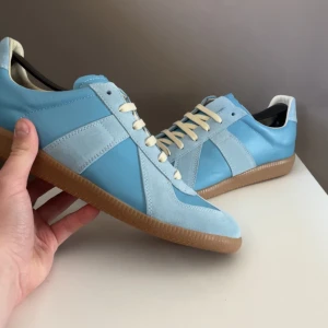 Maison Margiela  - Säljer dessa tvär feta Maison Margiela i färgen ljusblå! Skorna är helt nya, absolut inget tecken på användning. Skorna är i storlek 42 men passar både 41-43💯! Säljer endast för 3099 men priset är verkligen inte hugget i sten så kom med bud, nypris cirka 7500! För mer info eller fler bilder tveka inte på att höra av dig till mig🥂✅!