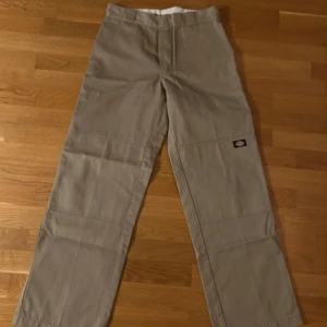 Beige cargopants från Dickies - Säljer ett par beige cargopants från Dickies med loose fit. Byxorna har en klassisk design med flera fickor och en bekväm passform. Perfekta för en avslappnad stil.