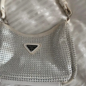 Vit glittrig axelväska  - Säljer en snygg vit axelväska täckt med glittrande stenar 