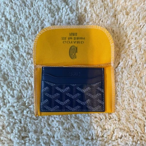Blå plånbok - Säljer ett elegant blått kortfodral från G🐡yard med deras ikoniska mönster. Fodralet har flera fack för kort och kommer med en gul skyddspåse. Perfekt för att hålla dina kort organiserade med stil.