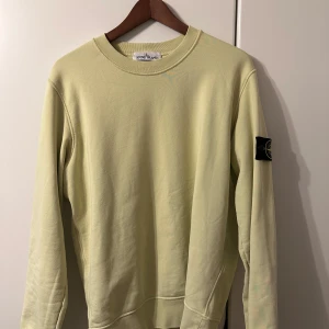 Stone Island Sweatshirt - Stone Island tröja i lite unikare färg (ljus grön/gul), perfekt för vårtid. Svart patch i bra skick. Köpt på NK. Storlek M.