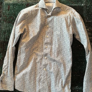 Mönstrad skjorta från Eton - Säljer en elegant mönstrad skjorta från Eton i en stilren design. Skjortan har en smal passform och är tillverkad i bomull. Den har långa ärmar och knappar framtill. Perfekt för en stilfull look. Storlek sitter som S/M