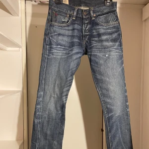 Blå jeans från Ralph Lauren - Säljer ett par snygga blå jeans från Ralph Lauren i bra skick. De har en klassisk femficksdesign med knappar och en cool tvättad look. Perfekta för både vardag och fest! 🕺