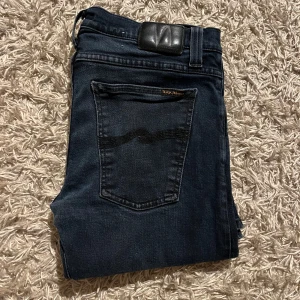 Mörkblå jeans från Nudie Jeans - Nudie jeans i fint skick. Står 34/34 på lappen men sitter mer som 32/32. Fint skick inga skador. Fraktas antigen samma dag som köp eller dagen därpå💯🙌