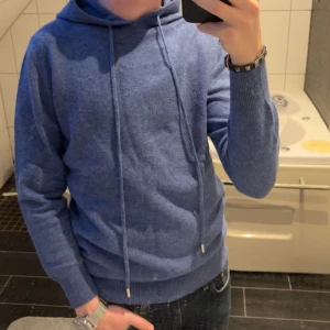 Blå hoodie - Säljer en stilren merinoull hoddie i färgen blå, använd några gånger men är i väldigt bra skick, jag på bilden är 176. Köpt för 1000kr så säljer för halva priset👍