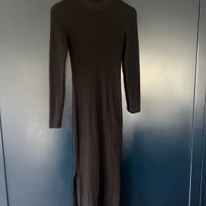 Svart ribbad långklänning - Snygg svart ribbad långklänning med långärmad design. Perfekt för en stilren look. Klänningen har en enkel och elegant passform. Säljer då jag tycker att den är för kort på mig! 🥰 