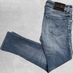 Blåa Jacob Cohen Jeans  - Säljer nu dessa riktigt feta Jacob Cohen Jeansen. Storlek 30. Model 688, Slim-Fit. Nyskick ser helt oanvända ut. Ny pris ca 5000kr! Mitt pris endast 1299✅. Hör av dig om du undrar något eller vill ha fler bilder! Totallängd ca 99cm, Från skrevet ca 71cm, Midje bredd ca 40cm, lår bredd 22cm, vad bredd 17cm, ben öppning 16.5.