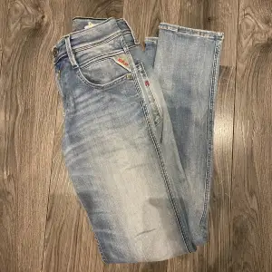 Snygga ljusblå jeans från replay i modellen Anbass med en klassisk femficksdesign och knappgylf. Perfekta för en avslappnad stil.                 Storleken är 30/32.
