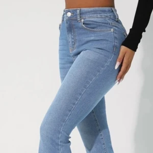 Blå högmidjade jeans - Snygga blå jeans med hög midja och klassisk femficksdesign. De har en knapp och dragkedja framtill och är perfekta för en stilren look. Passformen är tight och materialet är stretchigt för extra komfort.