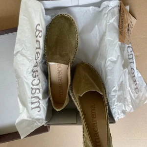 Olivgröna mocka skinn espadrillos från Macarena  - Snygga olivgröna espadrillos från spanska Macarena, perfekt för sommaren. Skorna är handgjorda med en ovandel i mocka och har en klassisk flätad sula. De är bekväma och stilrena, idealiska för en avslappnad look. Original kartong 