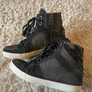 Svarta sneakers från Zadig & Voltaire - Så fina skor från zadig och Voltaire, storlek 38. Dom glittrar och är super söta nu till våren/ sommaren. Även väldigt eftertraktade 🥰Skorna har lite defekter på sulan (kom privat för bild och för att diskutera pris)
