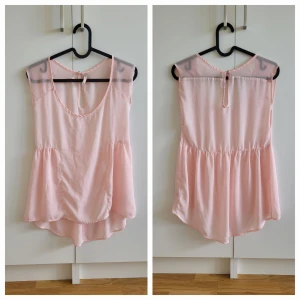 Ljusrosa blus från Bershka - Säljer en söt ljusrosa blus från Bershka. Blusen är ärmlös med transparenta axelpartier och har en luftig passform. Perfekt för varma dagar eller sommarens fester. 💖