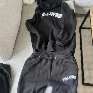Svart tracksuit från Fullypaid - Säljer en svart sällsynt tracksuit från Fullypaid med vit text på bröstet. Tröjan har en klassisk design med en stor ficka framtill och huva. Perfekt för en avslappnad stil. Byxorna har en liten skada vid ena fickan men inget som man tänker på. Pris kan diskuteras 