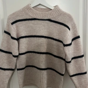 Beige randig tröja från Gina Tricot - Säljer en beige tröja med svarta ränder från Gina Tricot. Storlek 134/140.