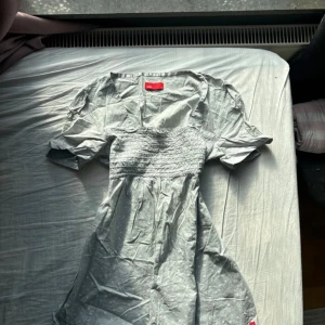 Ljusgrå topp från edc - Supersöt ljusgrå topp från edc med små vita blommor, puffiga kortärmar och smock över bysten. Toppen har v-ringning och är gjord i mjuk bomull, perfekt för en chill sommardag. Snygg och enkel att styla med sneakers eller sandaler. Babydoll top från edc by espirit som jag köpte för länge sedan och som fortfarande har ett bra skick 