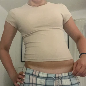 Beige croppad t-shirt - Säljer en enkel och stilren beige croppad t-shirt som knappt är använd. Skriv för fler detaljer/bilder😽