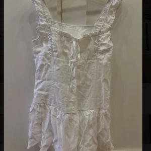 Vit kort sommarklänning med knyt - Använd 1 gång, det finns shorts under klänningen.