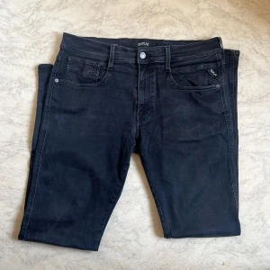 Replay jeans W34/L32 - Snygga svarta jeans från Replay med klassisk femficksdesign och diskreta Replay-detaljer på fickan. Jeansen har en rak passform och är tillverkade i mjukt denimtyg som sitter skönt hela dagen. Perfekta till sneakers eller boots.