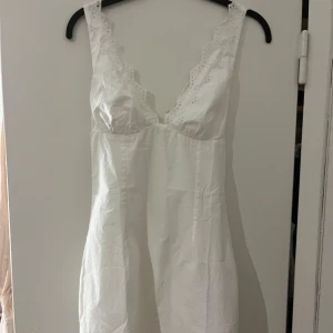 Vit kort klänning från Bershka - Supersöt vit kort klänning från Bershka med lappen kvar, aldrig använd!
