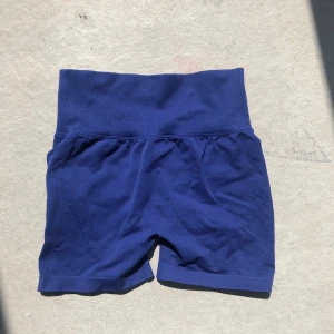 Blå seamless biker shorts - Snygga mörkblå biker shorts med hög midja och seamless design. Shortsen har en bred, ribbad midjeresår och scrunch-detalj bak för extra form. Perfekta för träning eller chill. Mjukt och stretchigt material som sitter skönt på kroppen.