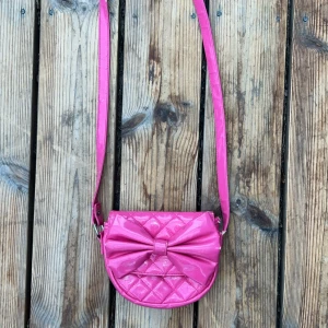 Rosa handväska - Säljer en rosa handväska som är i perfekt storlek. Använd ett fåtal gånger, inga tecken på användning. Bra kvalitet och även en fin rosett på. Priset kan diskuteras!💗